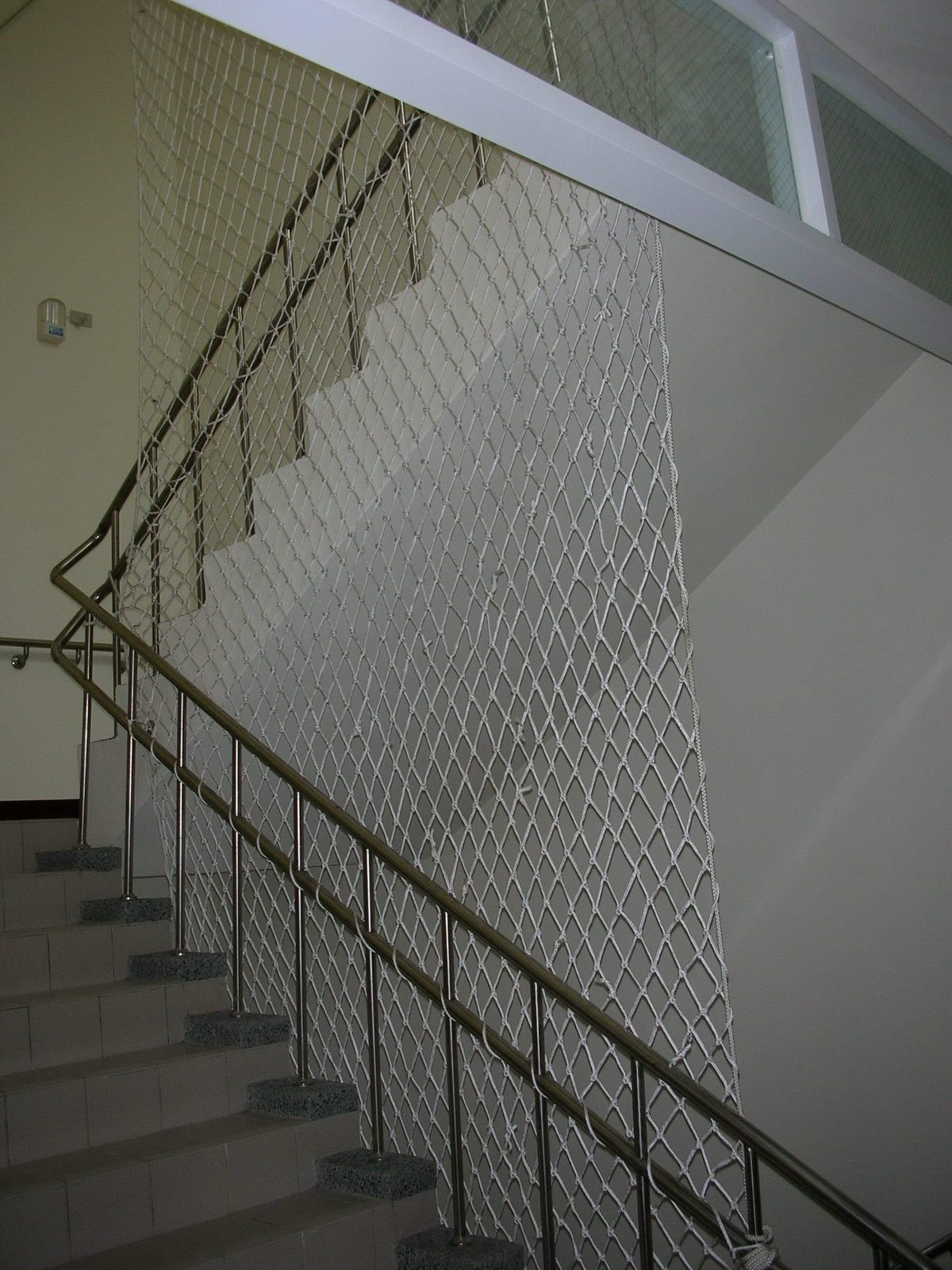 Protective netting beside a stair handrail