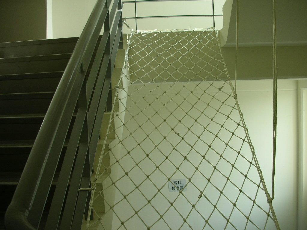 Inclined fall-arrest netting in a stairwell